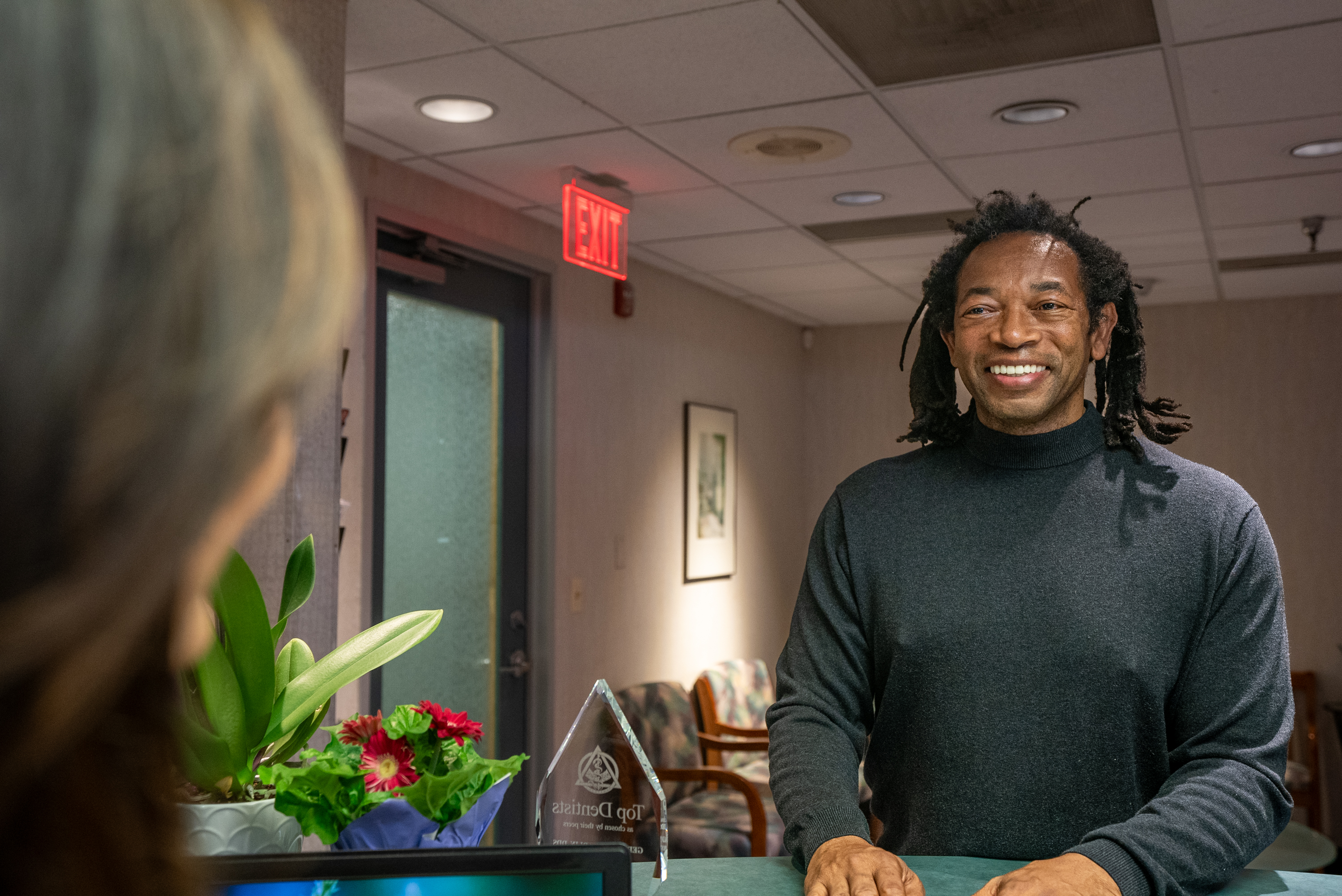 Professional dental implant care team member providing post-operative instructions to a recovering patient
